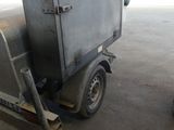 a small trailer with a trailer attached to it in a warehouse