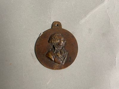 une photo d'un médaillon en bronze représentant un homme barbu