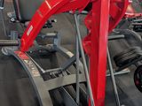 a row of machines in a gym with people in the background