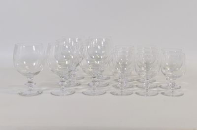 plusieurs verres à vin vides sont alignés sur une surface blanche