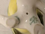 a small ceramic figurine of a man holding a banana
