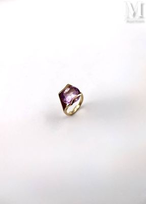 an image of a ring with a purple stone on a white surface