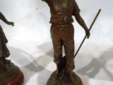 two bronze statues of a man and a woman on a pedestal