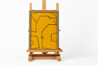 chevalet de peinture avec un tableau jaune sur fond blanc