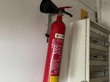 un extincteur accroché au mur à côté d'une borne d'incendie