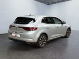the rear end of a silver car in a white room