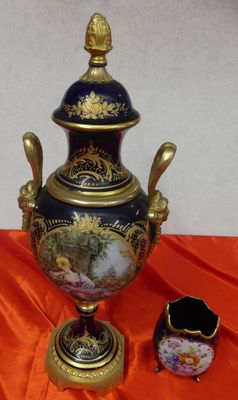 a vase with a lid sitting on an orange cloth