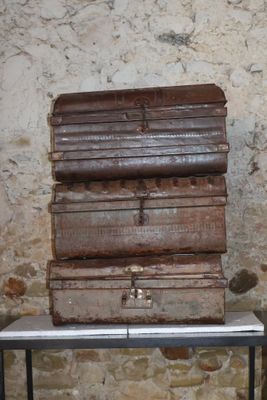 une pile de valises posée sur une table devant un mur en pierre
