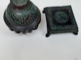 a green candle that is sitting next to a small book