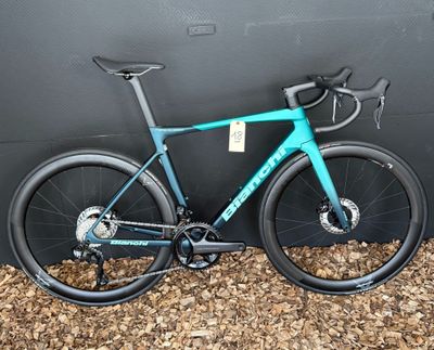 un vélo bleu garé contre un mur, devant un mur noir