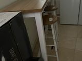 une petite cuisine équipée d'un réfrigérateur et d'une petite table