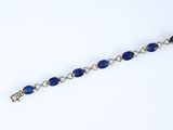 a close up of a bracelet with blue beads on a white background