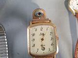 two watches and a watch bracelet on a table