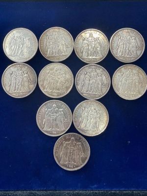 a collection of silver coins in a glass case