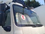 un grand camion blanc garé devant un immeuble
