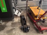 un chariot et un diable dans un garage, sur lequel est accrochée une pancarte