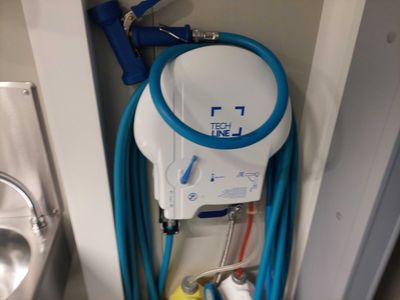un tuyau bleu fixé au mur à côté d'un évier