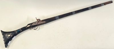 an old gun with a wooden handle on a white surface