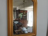 un miroir accroché au mur à côté d'un radiateur