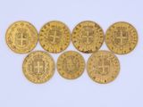 a group of five gold coins with the symbols of different countries
