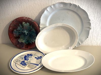 trois assiettes et un bol posés sur une table à côté d'une plante