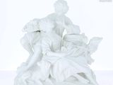 une figurine blanche représentant une femme tenant un panier de fleurs