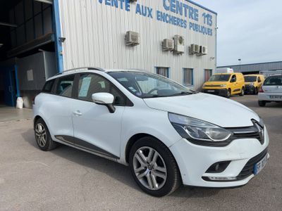 une voiture blanche garée devant un bâtiment dans un parking