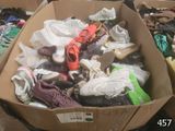 plusieurs paires de chaussures dans une boîte en carton posée sur le sol