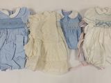 trois vêtements pour bébé sont alignés sur une surface blanche