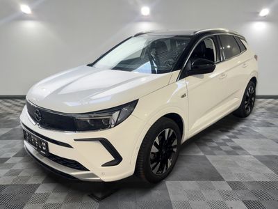 un 4x4 blanc garé sur un sol en damier dans un garage