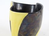 a black and yellow bowl sitting on a white surface