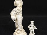 une figurine blanche représentant un garçon tenant un oiseau, à côté d'une petite figurine représentant un garçon