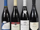 several bottles of wine are lined up on a glass table