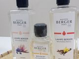 three bottles of cologne sitting on top of a wicker tray