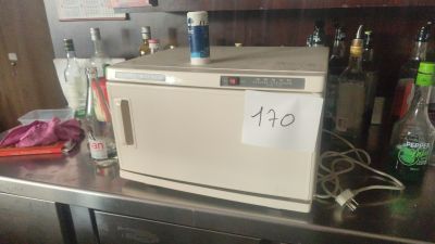 a microwave sitting on top of a counter next to bottles of alcohol