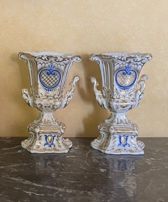 deux vases posés sur une table, avec un mur en arrière-plan