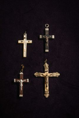 four crosses are displayed on a black surface with a black background