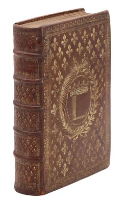 un vieux livre marron avec un motif doré sur la couverture