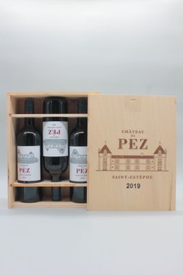 trois bouteilles de vin dans un coffret en bois sur une table