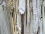 a lot of wedding dresses hanging on a rack