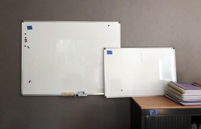a white board on the wall next to a pile of books