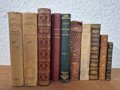several old books are lined up on a wooden table