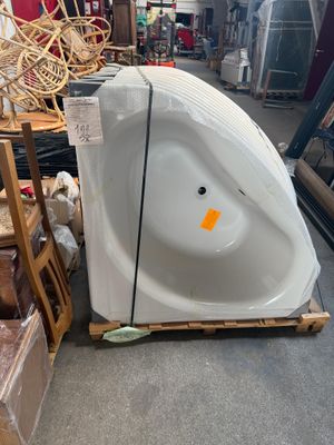 une baignoire blanche posée sur une palette dans un magasin
