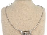 un collier en argent orné d'un oiseau, porté par un mannequin