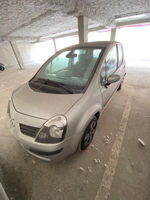 une petite voiture argentée garée dans un parking couvert