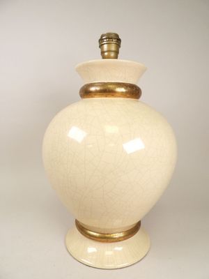 LE DAUPHIN. Lampe en céramique émaillée et craquelée ivoire,…