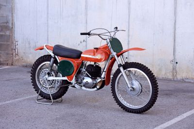a motorcycle parked in a parking lot next to a wall