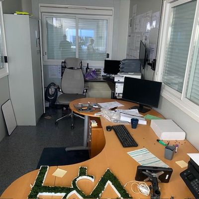 un bureau sur lequel se trouvent un ordinateur, un clavier, un écran et d'autres objets