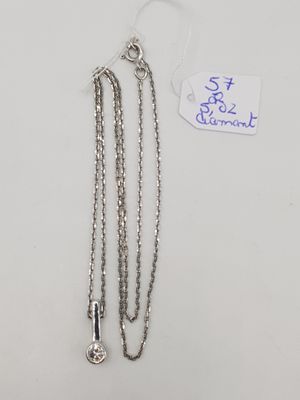 un gros plan sur une paire de chaînes argentées posées sur une surface blanche