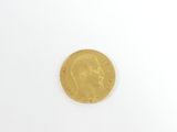 gros plan d'une pièce d'or sur une surface blanche